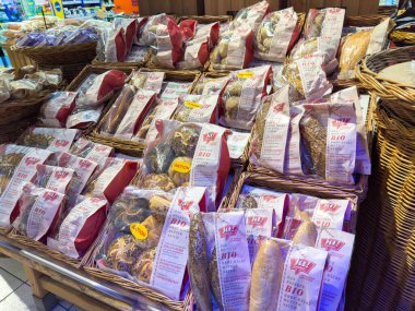 Villach, Avusturya - 21 Ağustos 2025: Markette dokunmuş sepetlerdeki organik ekmek çeşitleri, gıda aşıkları için çeşitli dokuları ve renkleri vurguluyor