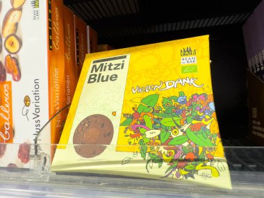 Villach, Avusturya - 21 Ağustos 2025: Mitzi Blue çikolata kutusu dikkat çeken renkli grafikler ve sanatsal tasarım unsurlarının yer aldığı bir rafta sergilenmektedir