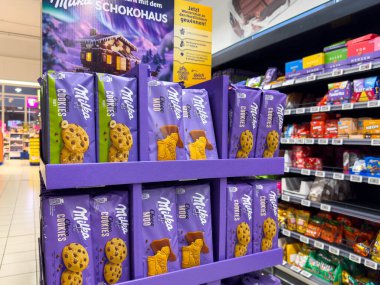 Villach, Avusturya - 21 Ağustos 2025: Milka çikolatalı kurabiyeleri bir markette canlı paketleme ve tanıtım malzemeleriyle perakende satış rafında sergileniyor