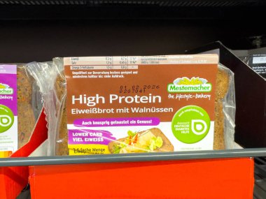 Villach, Avusturya - 21 Ağustos 2025: Cevizli Mestemacher Yüksek Protein Ekmeği, besleyici abur cubur seçeneklerini ön plana çıkaran bir süpermarket rafında sergilenmektedir