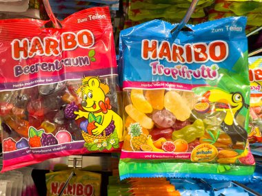 Villach, Avusturya - 21 Ağustos 2025: İki Haribo şeker torbası, Beerentraum ve Tropifrutti, renkli ambalajlarını ön plana çıkaran bir mağaza rafında sergileniyor.