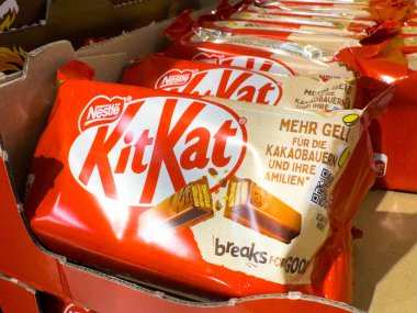 Villach, Avusturya - 21 Ağustos 2025: KitKat çikolataları parlak kırmızı ambalajlar ve çekici gofret katmanlarıyla perakende bir ortamda belirgin bir şekilde sergilenmektedir