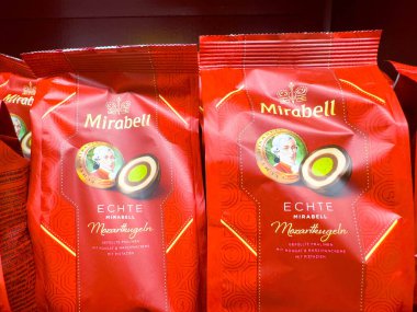 Villach, Avusturya - 21 Ağustos 2025: Mirabell Echte Mirabellen Maxihugel çikolata torbaları zengin kırmızı renkler ve zarif markaların yer aldığı bir rafta sergilenmektedir