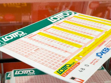 Villach, Avusturya - 21 Ağustos 2025: Sayılar ve oyuncuların seçeneklerinin yer aldığı tezgahta piyango bileti, piyango katılımının heyecanını yakalamak