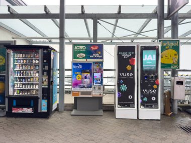 Villach, Avusturya - 21 Ağustos 2025: Otomatlar, cam çatılı çağdaş bir alışveriş alanında piyango biletleri, sigara ve içecekler sergiliyor