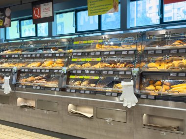 Villach, Avusturya - 21 Ağustos 2025: Fırın vitrininde bir dizi taze ekmek ve hamur işi yer alıyor, müşterileri lezzetli pişmiş ürünleri keşfetmeye davet ediyor