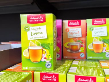Villach, Avusturya - 21 Ağustos 2025: Westminster İtalyan Limonlu Çay Kutusu, farklı aromalı renkli ambalajlarla çevrili bir süpermarket rafında belirgin bir şekilde sergilenmektedir.