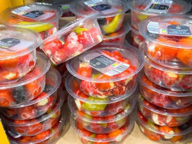 Villach, Avusturya - 21 Ağustos 2025: Temiz kaplarda taze kiraz domatesleri sergileniyor, canlı renklerini vurguluyorlar ve sağlıklı beslenme seçeneklerini destekliyorlar