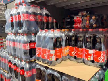 Villach, Avusturya - 21 Ağustos 2025: Coca-Cola şişeleri bir süpermarket rafında organize edilerek, kolay görülebilirlik için ikonik kırmızı markalaşma ve açık ambalajı vurgulanıyor
