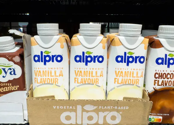 Villach, Avusturya - 21 Ağustos 2025: Alpro vanilya ve çikolata aromalı bitkisel içecekler, çekici ambalajlarını vurgulayarak, perakende satış rafında güzelce düzenlenir