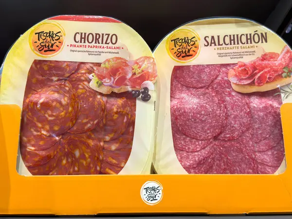 Villach, Avusturya - 21 Ağustos 2025: Chorizo ve Salchichon etleri turuncu bir tepside güzel bir şekilde düzenlenmiştir, besin sunumu için zengin renklerini ve dokularını vurgularlar