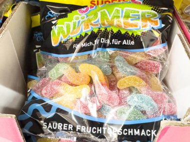 Villach, Avusturya - 24 Ağustos 2025: Açık bir poşette sergilenen renkli jelibon solucanları, canlı şeker çeşitlerini ve neşeli markalaşmayı vurguluyor