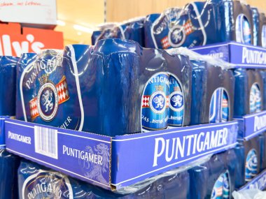 Villach, Avusturya - 24 Ağustos 2025: Puntigamer bira paketleri, çekici mavi markalaşma ve ambalaj tasarımını ön plana çıkaran, perakende bir ortamda düzenli olarak düzenlenmiştir