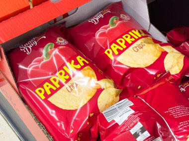 Villach, Avusturya - 24 Ağustos 2025: Kırmızı biber cipsleri bir markette renklendirilmiş ambalajlar ve cazip atıştırmalık seçenekleri vurgulanıyor