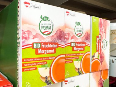 Villach, Avusturya - 24 Ağustos 2025: Organik meyve çay kutuları renkli tasarımları ve fotokopi alanı ile çevre dostu markalaşmalarını ön plana çıkaran bir rafa yerleştirildi