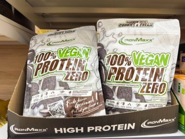 Villach, Avusturya - 24 Ağustos 2025: IronMaxx% 100 Vegan Protein Sıfır torbaları, fitness aşıkları için kurabiyeleri ve krema tadını ön plana çıkaran bir rafta sergilenmektedir