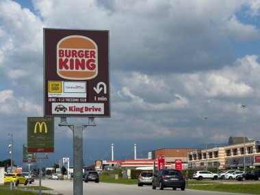 Udine, İtalya - 26 Ağustos 2025: Burger King tabelası yol kenarında McDonald 's manzaralı, fast food seçenekleri ve canlı çevrenin altını çiziyor