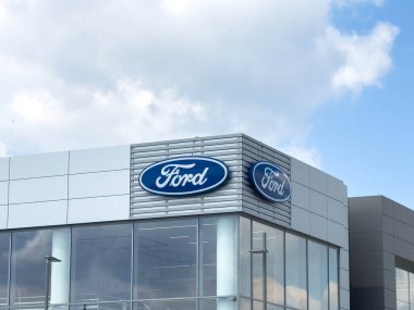 Udine, İtalya - 26 Ağustos 2025: Parlak mavi bir gökyüzü altında parlak cam tasarımı ve ikonik Ford logosunun yer aldığı Ford bayiliğinin dış görünümü