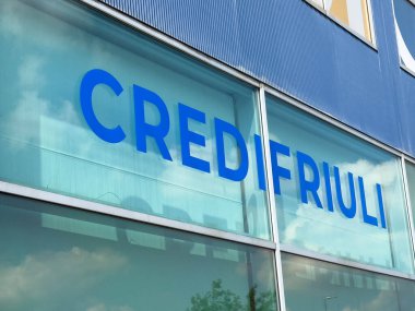 Udine, İtalya - 26 Ağustos 2025: Credifriuli banka logosu cam cephede görülebilir, gökyüzünü ve bulutları yansıtıyor, modern mimari ve markalaşmayı ön plana çıkarıyor
