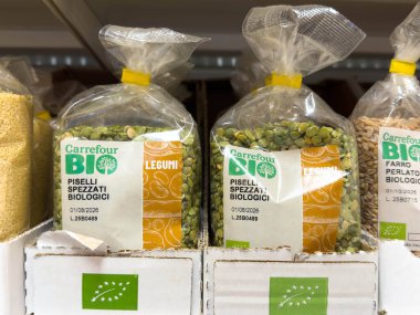 Udine, İtalya - 26 Ağustos 2025: Bakkal rafındaki temiz poşetlerdeki dört BIO organik bezelye, sürdürülebilir ve sağlıklı gıda seçeneklerini vurguluyor