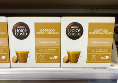 Udine, İtalya - 26 Ağustos 2025: Nescafe Dolce Gusto Cortado Espresso kahve kapsülleri bir rafa dizilmiş, marka ve ürün detaylarını vurguluyor