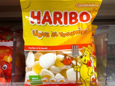 Udine, İtalya - 26 Ağustos 2025: Haribo şeker paketi Uova al Tegamino şekerlerini eğlenceli grafiklerle dolu parlak sarı bir çantada gösteriyor