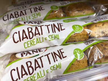Udine, İtalya - 26 Ağustos 2025: Mısır gevreği ve tohumlu ciabattine ekmeği ambalajda sergileniyor, bakkalda sergileniyor, tazelik ve kaliteyi vurguluyor