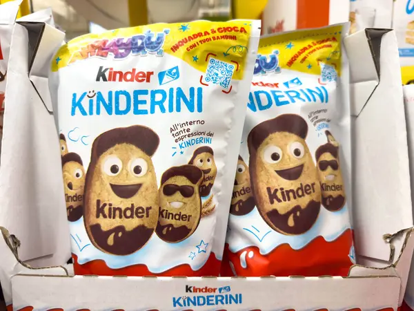 Udine, İtalya - 26 Ağustos 2025: Kinderini atıştırmalık paketleri eğlenceli karakterler ve parlak ambalajlı çocuklar için tasarlanmış bir mağaza ortamında sergilendi