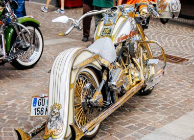 Villach, Avusturya - 05 Eylül 2025: Özel Harley Davidson motosikleti, Avrupa Bisiklet Haftası sırasında, coşkulu motosikletçiler ve canlı ambiyansla çevrili, çarpıcı altın detaylar içeriyor