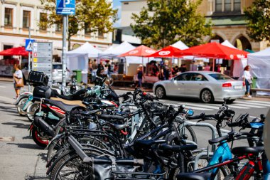 Villach, Avusturya - Eylül 05, 2025: Avrupa Bisiklet Haftası sırasında Harley Treffen etkinliği güneşli bir şehir ortamında park halindeki motosikletleri ve canlı pazar yerlerini ön plana çıkarıyor