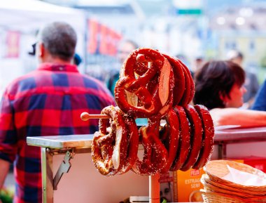 Villach, Avusturya - Eylül 05, 2025: Taze krakerler neşeli müşteriler ve canlı renklerle çevrili hareketli bir pazarda sergileniyor
