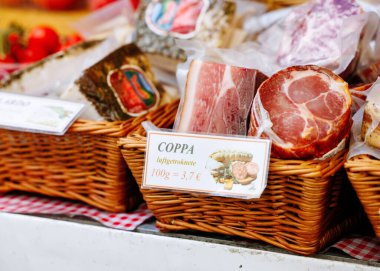 Villach, Avusturya - 05 Eylül 2025: Coppa da dahil olmak üzere çeşitli haşlanmış etler canlı bir pazarda sepetlerde güzelce düzenlenmiştir.