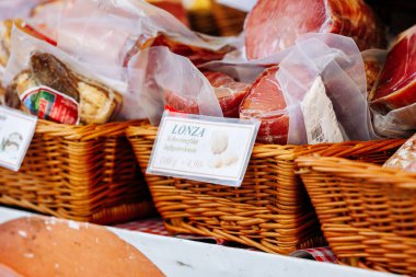 Villach, Avusturya - Eylül 05, 2025: Markette hasır sepetlerde çeşitli pişirilmiş etler, geleneksel lezzetler ve canlı renkler vurgulanıyor