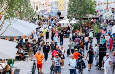 Villach, Avusturya - 05 Eylül 2025: Şehir caddesi insanlarla, açık kafelerle ve dükkanlarla dolup taşıyor, canlı atmosfer ve toplum ruhunu yansıtıyor