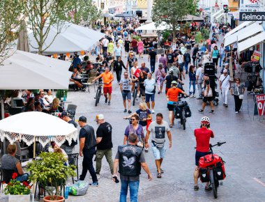 Villach, Avusturya - 05 Eylül 2025: Çevrede yiyecek, alışveriş ve sosyalleşmenin keyfini çıkaran çeşitli kişilerle dolu canlı sokak pazarı