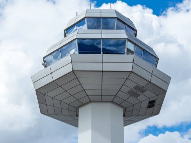 Klagenfurt, Avusturya - 25 Eylül 2025: Havalimanı kontrol kulesi canlı bir seyahat ortamında hava trafiğini denetleyen parlak tasarım ve geniş pencereler içeriyor