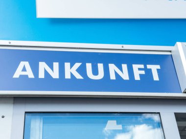 Klagenfurt, Avusturya - 25 Eylül 2025: Havalimanı varış işareti, yolcuları varış noktalarına yönlendiren parlak mavi bir arkaplan üzerinde beyaz harflerle Ankunft sözcüğünü içeriyor