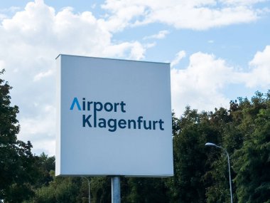 Klagenfurt, Avusturya - 25 Eylül 2025: Havalimanı Klagenfurt tabelası güzel bir gökyüzüne karşı sergileniyor, ziyaretçileri bölgeyi ve cazibesini keşfetmeye çağırıyor