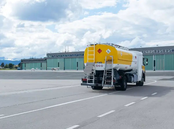 Klagenfurt, Avusturya - 25 Eylül 2025: Havaalanı yakıt kamyonu hangara doğru hareket ederek, temel havacılık destek operasyonları ve altyapısını vurguluyor