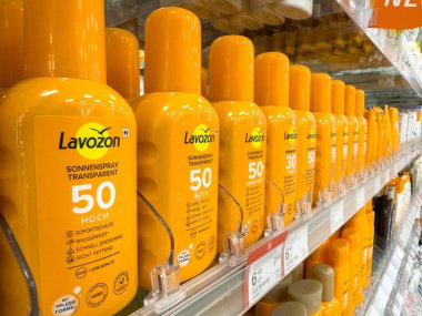 Villach, Avusturya - 17 Eylül 2025: Lavozon güneş kremi şişeleri bir perakende satış rafında sergileniyor, parlak sarı renk ve güneş koruma avantajları vurgulanıyor