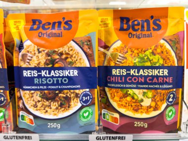 Villach, Avusturya - 17 Eylül 2025: Risotto ve Chili Con Carne da dahil olmak üzere Ben 'in orijinal pirinç paketleri bir bakkal koridorunda sergilenmektedir.