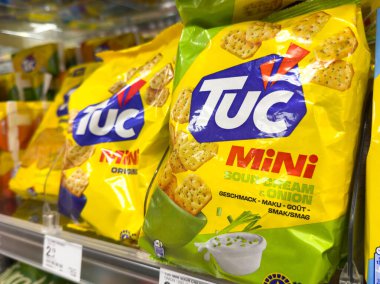 Villach, Avusturya - 17 Eylül 2025: Tuc Mini ekşi krema ve soğanlı abur cubur paketleri süpermarket raflarında belirgin bir şekilde sergileniyor, müşterileri keşfetmeye davet ediyor