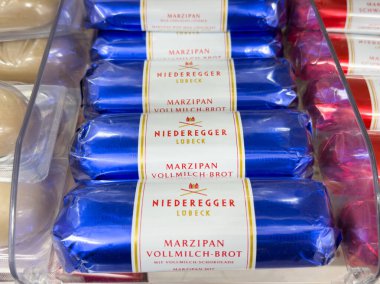 Villach, Avusturya - 17 Eylül 2025: Niederegger Lubeck 'ten Marzipan çikolataları, parlak mavi ambalajlarının altını çizerek güzel bir şekilde yerleştirilmiştir.