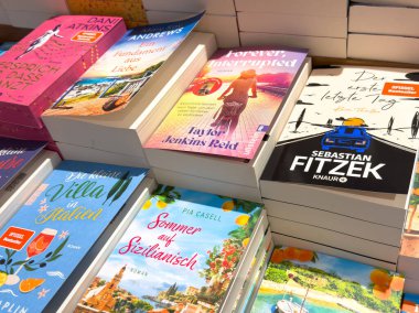 Villach, Avusturya - 17 Eylül 2025: Bir kitapçıda çeşitli türler ve göz alıcı kapakların yer aldığı canlı kitap koleksiyonu