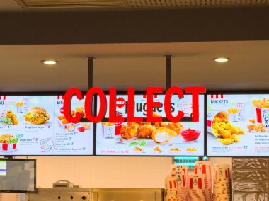Villach, Avusturya - 17 Eylül 2025: KFC menüleri canlı bir restoran ortamında lezzetli yemek seçenekleri ve tanıtım mesajları sunuyor