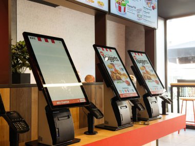 Villach, Avusturya - 17 Eylül 2025: KFC self-servis büfeleri çağdaş bir fast-food ortamında dijital menüleri sergiliyor, müşteri kolaylığı ve verimliliğini artırıyor