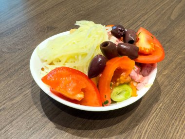 Domatesli, zeytinli ve doğranmış sebzeli taze Akdeniz salatası..