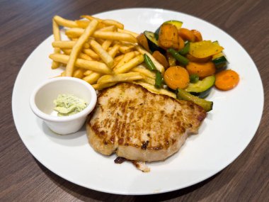 Lezzetli ızgara tavuk bifteği, patates kızartması ve karışık sebzeler..