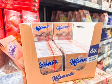 Villach, Austria - September 28, 2025: Manner wafer cookies are neatly arranged in a grocery store, highlighting the attractive packaging and product details