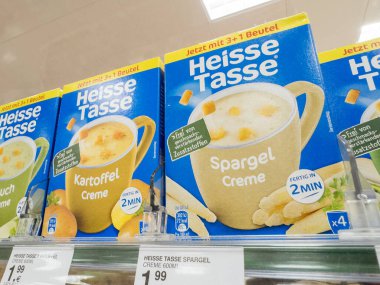 Villach, Austria - September 28, 2025: Heisse Tasse soup packages are neatly arranged on a supermarket shelf, featuring potato and asparagus flavors